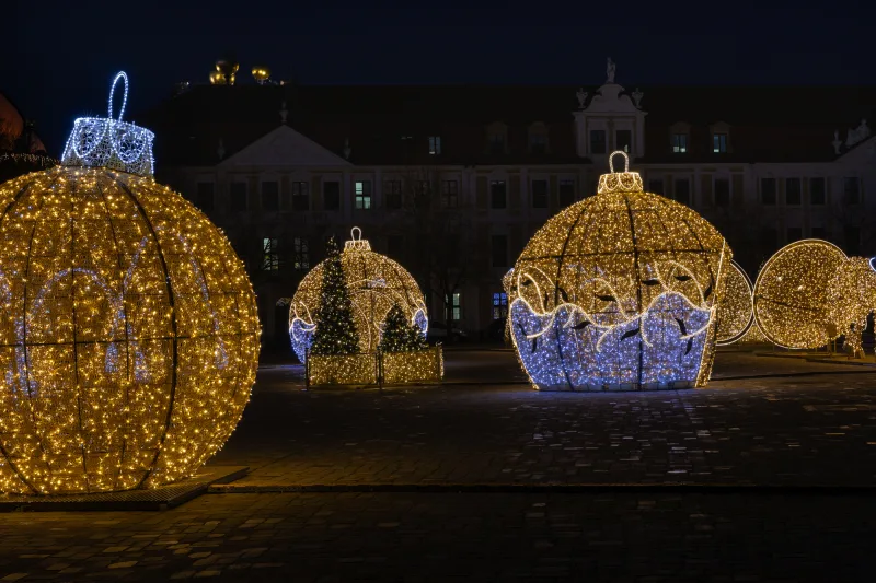 © Ilari - stock.adobe.com Beleuchtete Weihnachtskugeln auf einem abendlichen Platz
