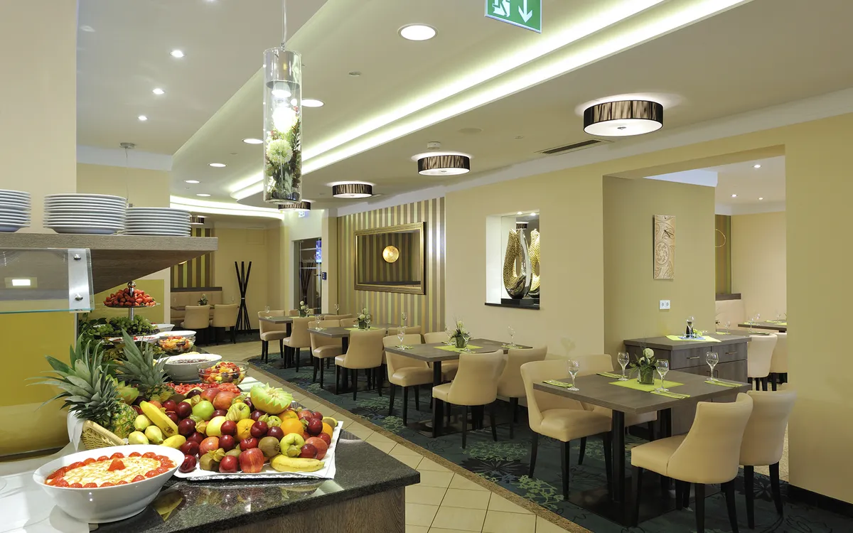 Restaurant mit gedeckten Tischen und Obstbuffet im Königshof Bad Füssing.