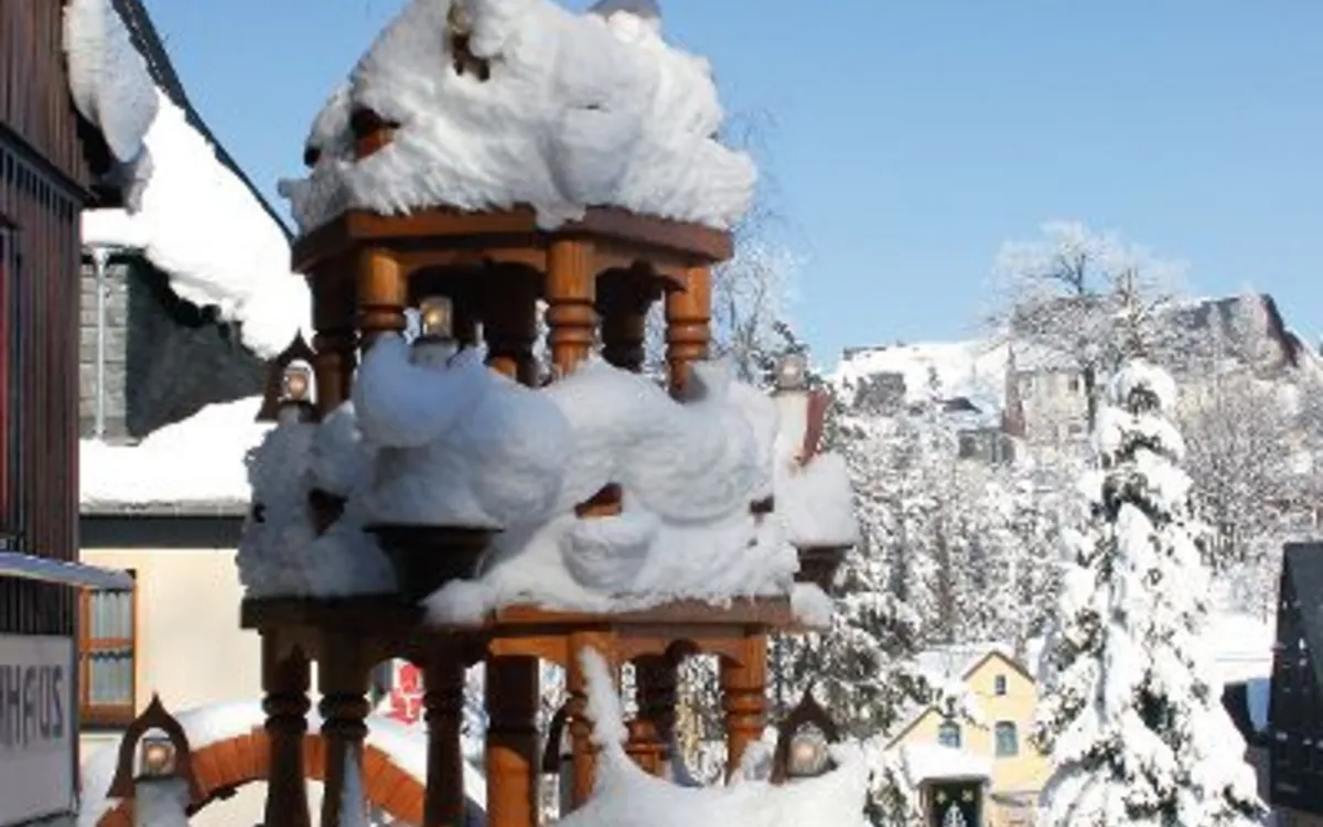 Verschneite Weihnachtspyramide in Seiffen, Erzgebirge, mit detailreichen Flügeln.
