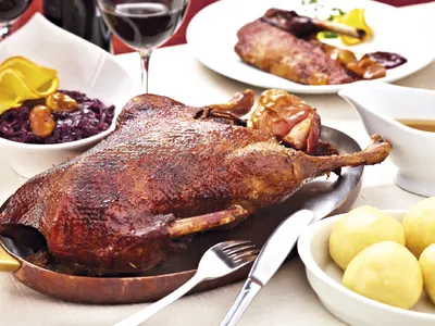 Knuspriger Gänsebraten mit Rotkraut und Kartoffelknödel auf einem festlichen Teller.