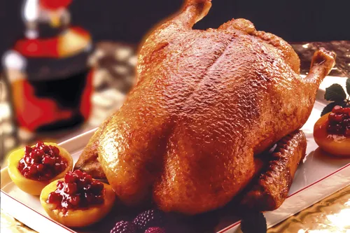 Knuspriger Gänsebraten auf einer Platte mit Beilagen.