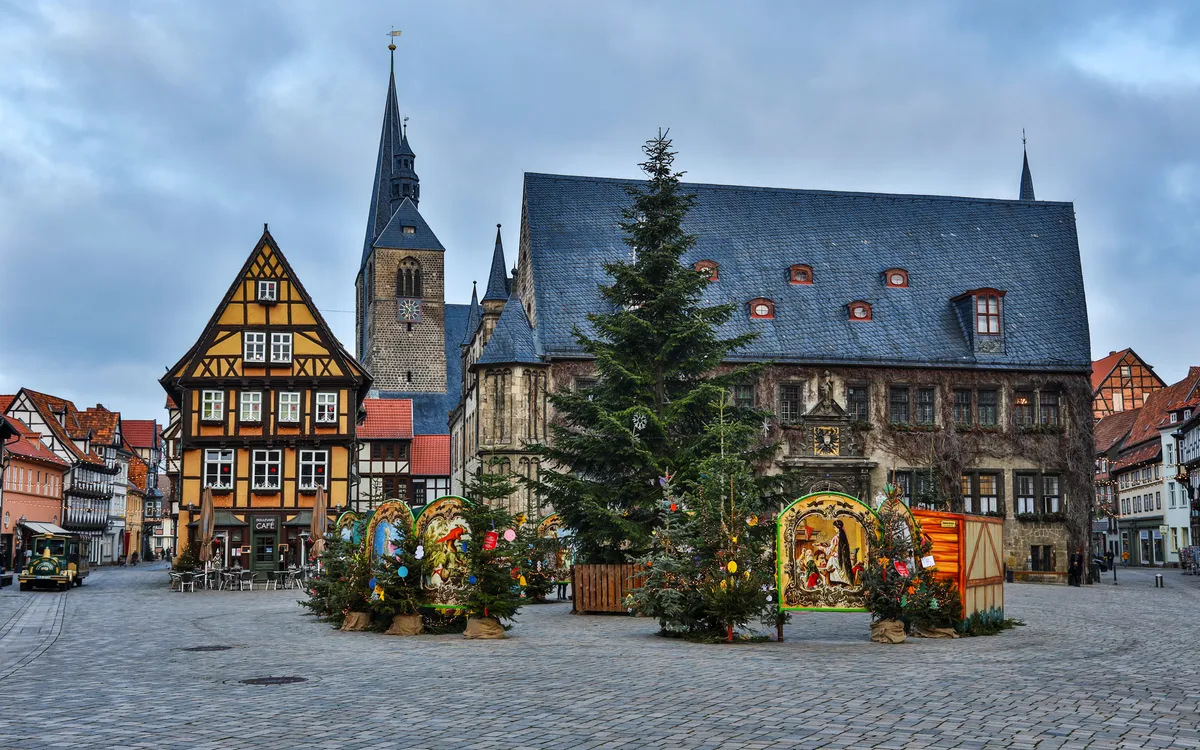 Städtischer Platz mit Fachwerkhäusern und Weihnachtsdekorationen.