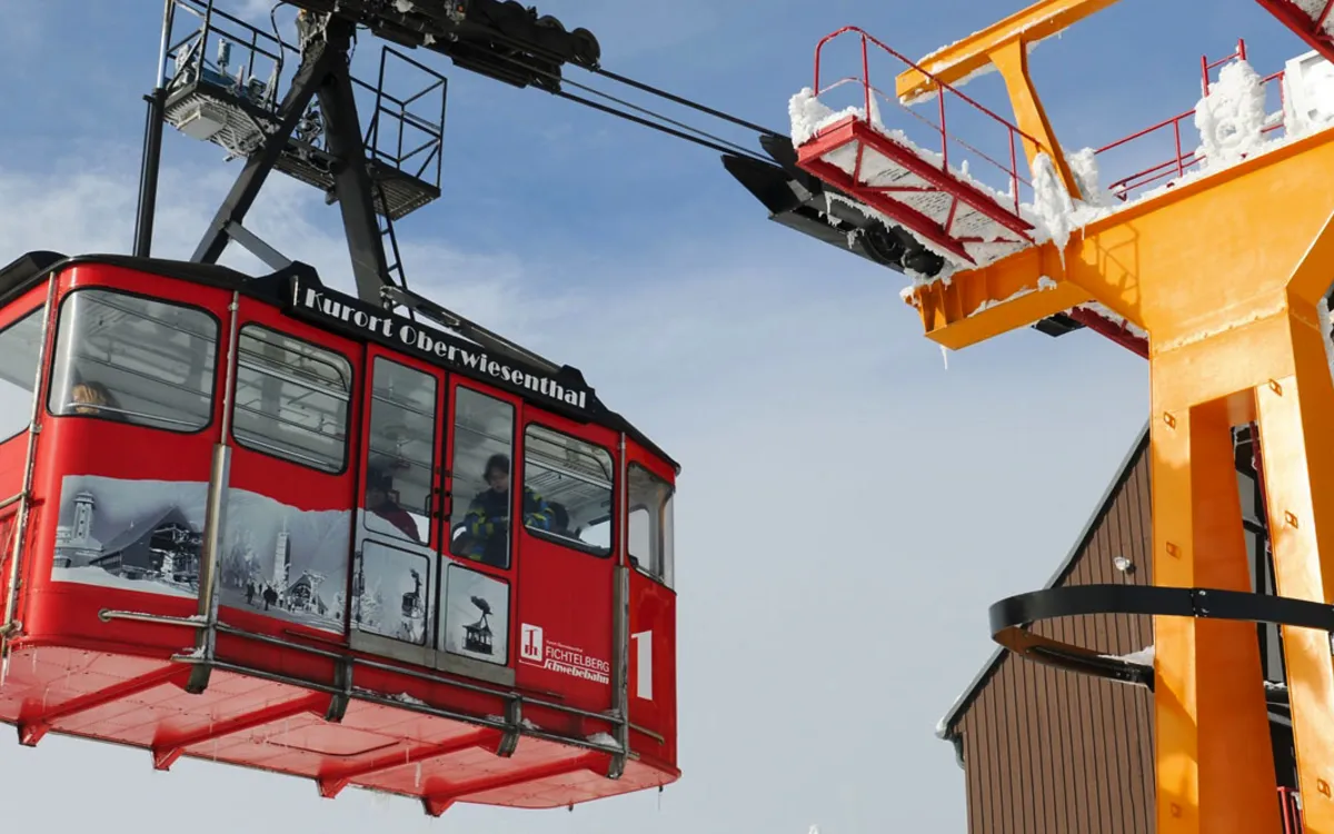 Rote Seilbahn der Fichtelberg-Schwebebahn in Oberwiesenthal vor blauem Himmel