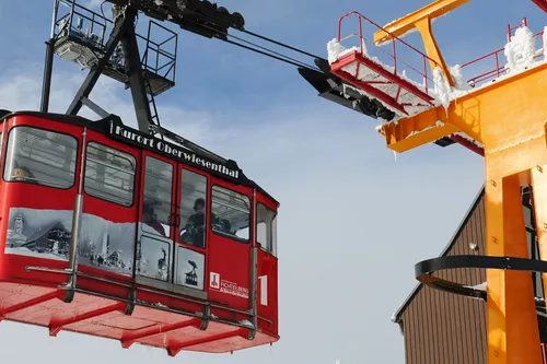 Rote Seilbahn der Fichtelberg-Schwebebahn in Oberwiesenthal vor blauem Himmel