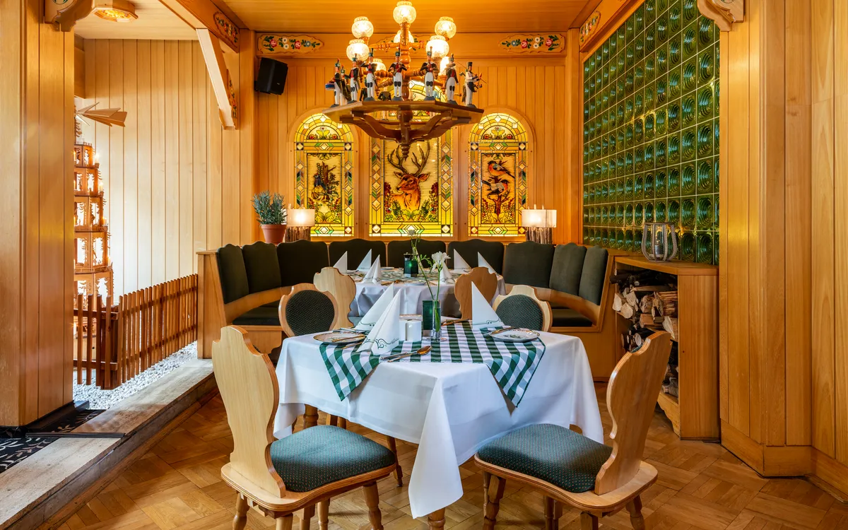 Gemütlicher Speiseraum im Ahorn Hotel Oberwiesenthal mit gedecktem Tisch und Holzinterieur.