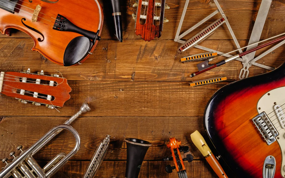 Viele Musikinstrumente auf Holzhintergrund arrangiert.