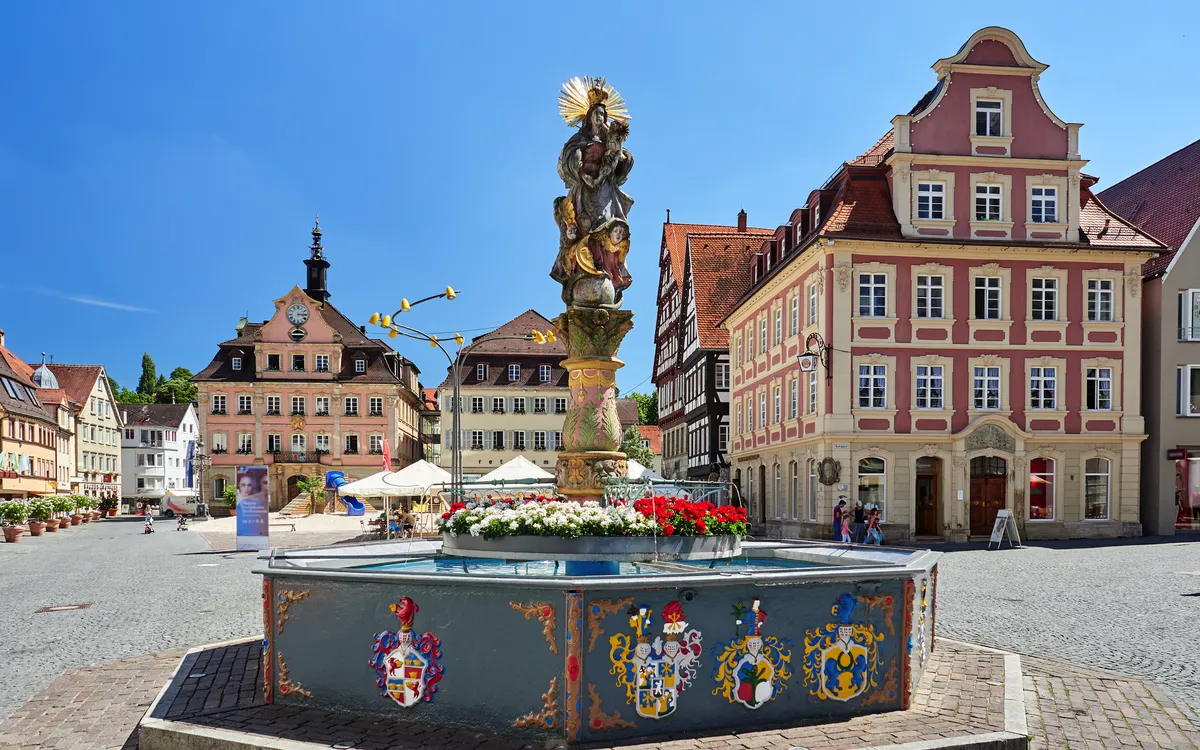 Ein Brunnen auf dem Marktplatz von Schwäbisch Gmünd, umgeben von historischen Gebäuden.