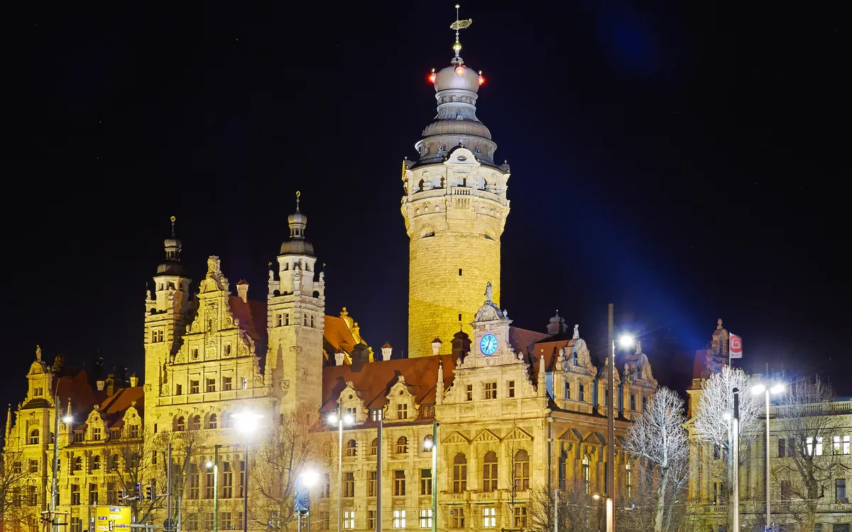 Nachtsicht auf das Neue Rathaus in Leipzig mit beleuchtetem Turm und historischer Architektur.