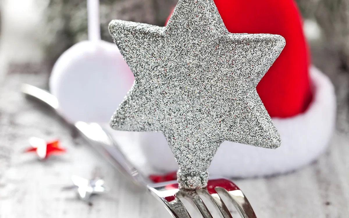 Weihnachtlich gedeckter Tisch mit Dekoration und Besteck.