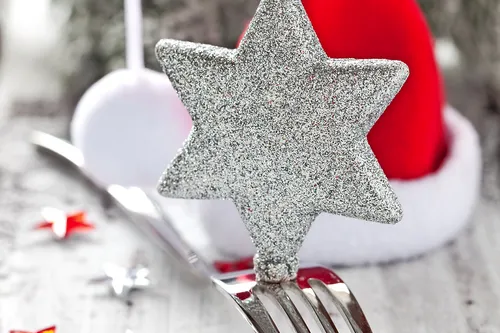Weihnachtlich gedeckter Tisch mit Dekoration und Besteck.