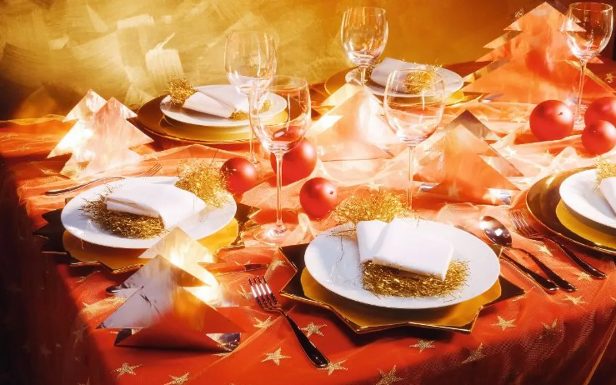 Festlich gedeckter Weihnachtstisch mit goldener Dekoration und Weihnachtskugeln.