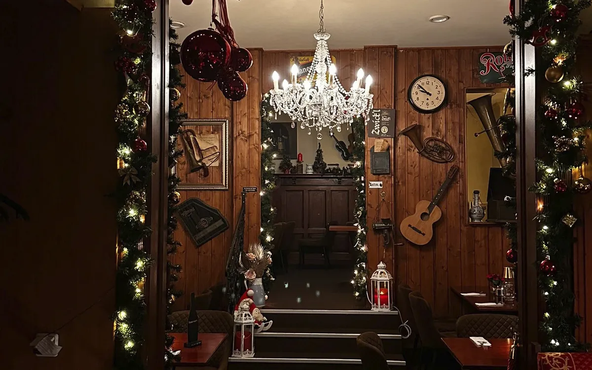Weihnachtlich dekorierter Durchgang im Restaurant Schaukelpferd mit Kronleuchter.