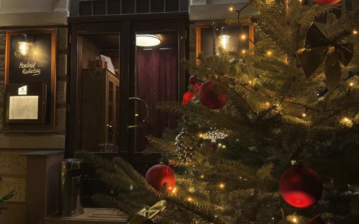 Eingang des Restaurants Schaukelpferd, weihnachtlich dekoriert mit Lichterbaum.