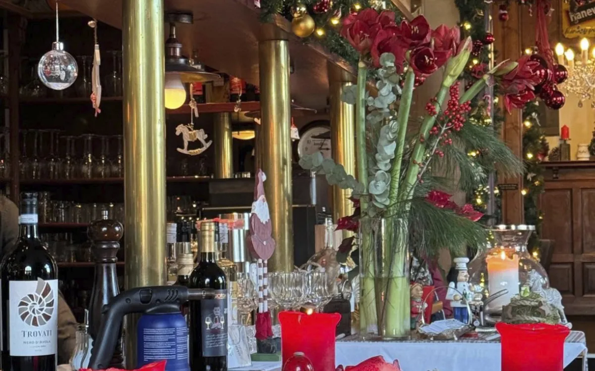 Weihnachtlich dekoriertes Restaurant mit Kranz und roten Kerzen.