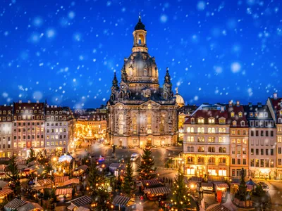 Weihnachtsmarkt vor der beleuchteten Frauenkirche, Neumarkt Dresden bei Schnee.