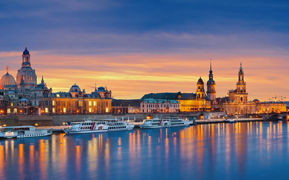Dresden bei Dämmerung mit Elbe, Frauenkirche und Schiffen im Winter.
