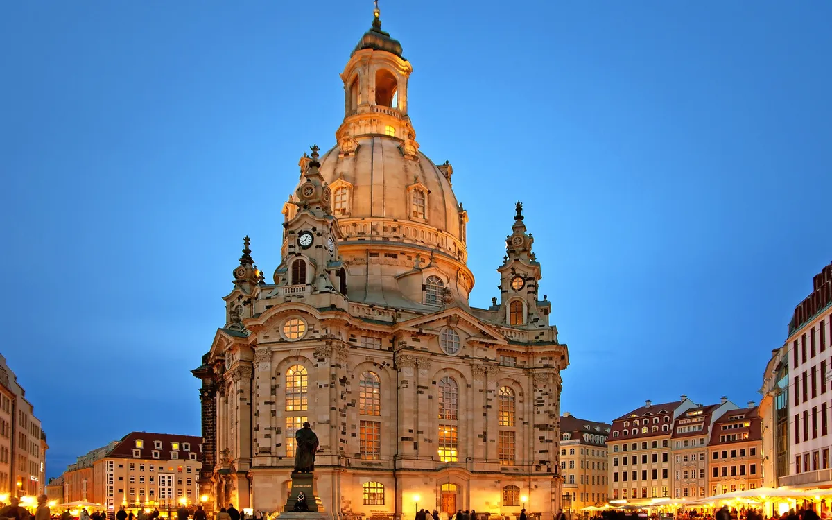 Frauenkirche in Dresden bei Abenddämmerung, beleuchtet, mit umliegendem Neumarkt.