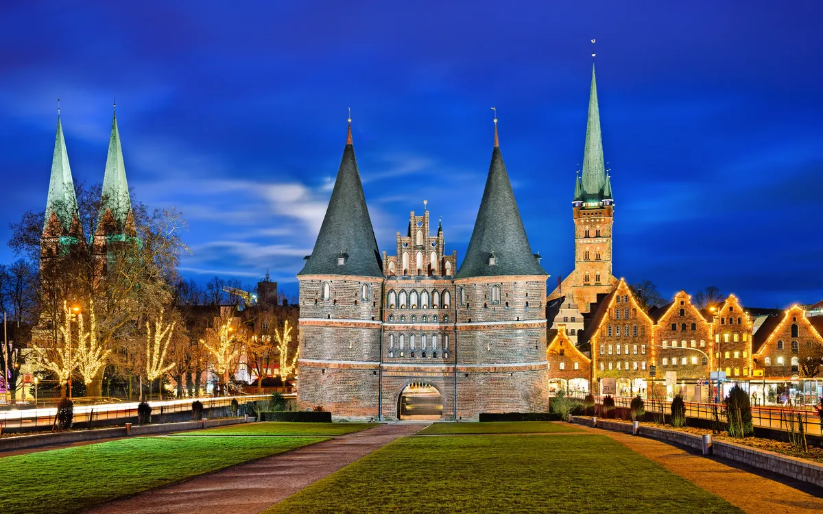 Holstentor in Lübeck bei Nacht im Winter mit Weihnachtsbeleuchtung