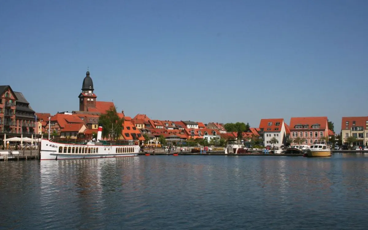 Stadtansicht mit Hafen, Schiffen und Kirchturm am Müritzsee in Waren.