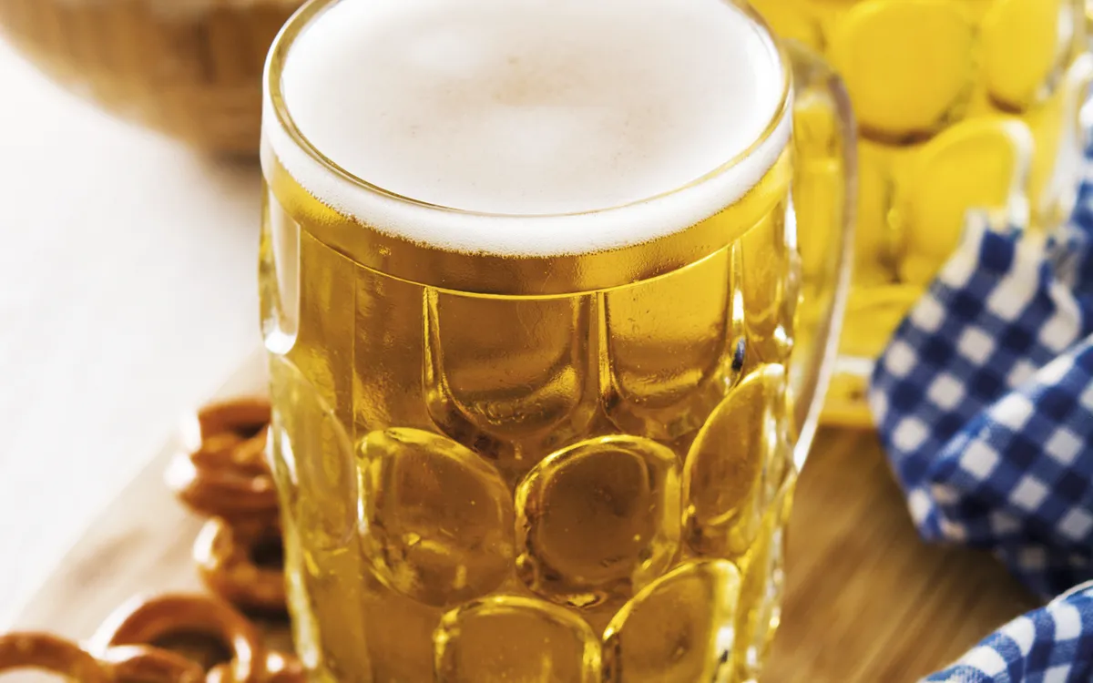 Oktoberfest beer and pretzel on wooden table.