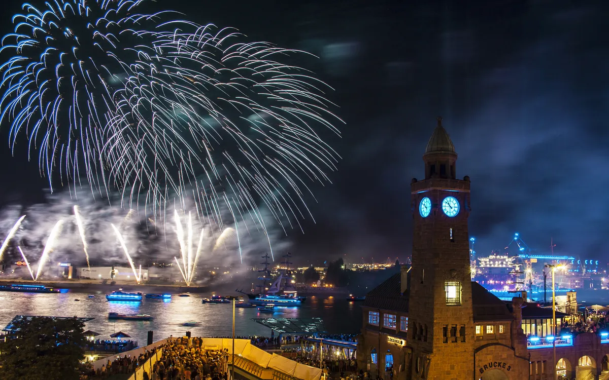 Feuerwerk über dem Hamburger Hafen mit Elbphilharmonie und Containerschiff.