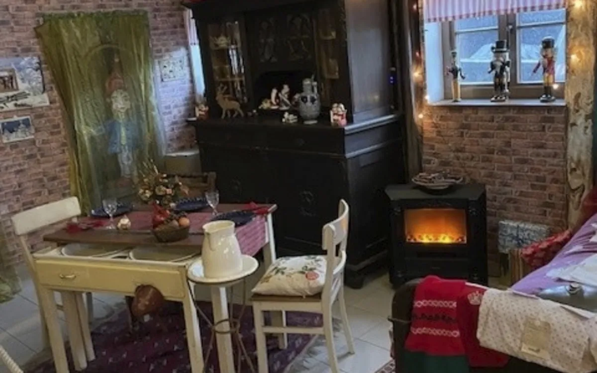 Gemütlich dekorierter Raum mit Weihnachtsschmuck und Kamin.