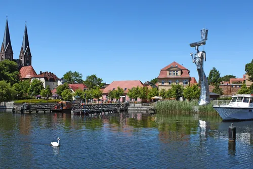 Stadtansicht von Neuruppin am Ruppiner See mit Kirche und Bootsanleger.