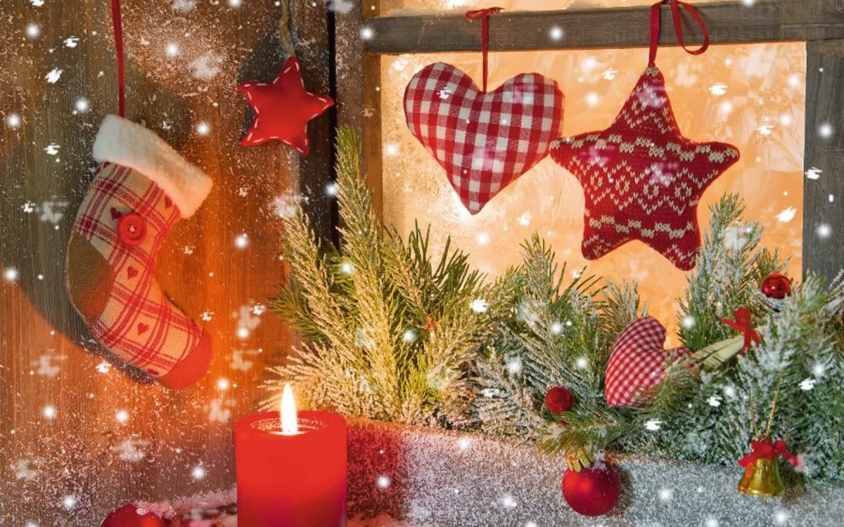 Weihnachtliche Dekoration mit Kerze, Tannenzweigen, Sternen und Nikolausstiefel am Fenster.