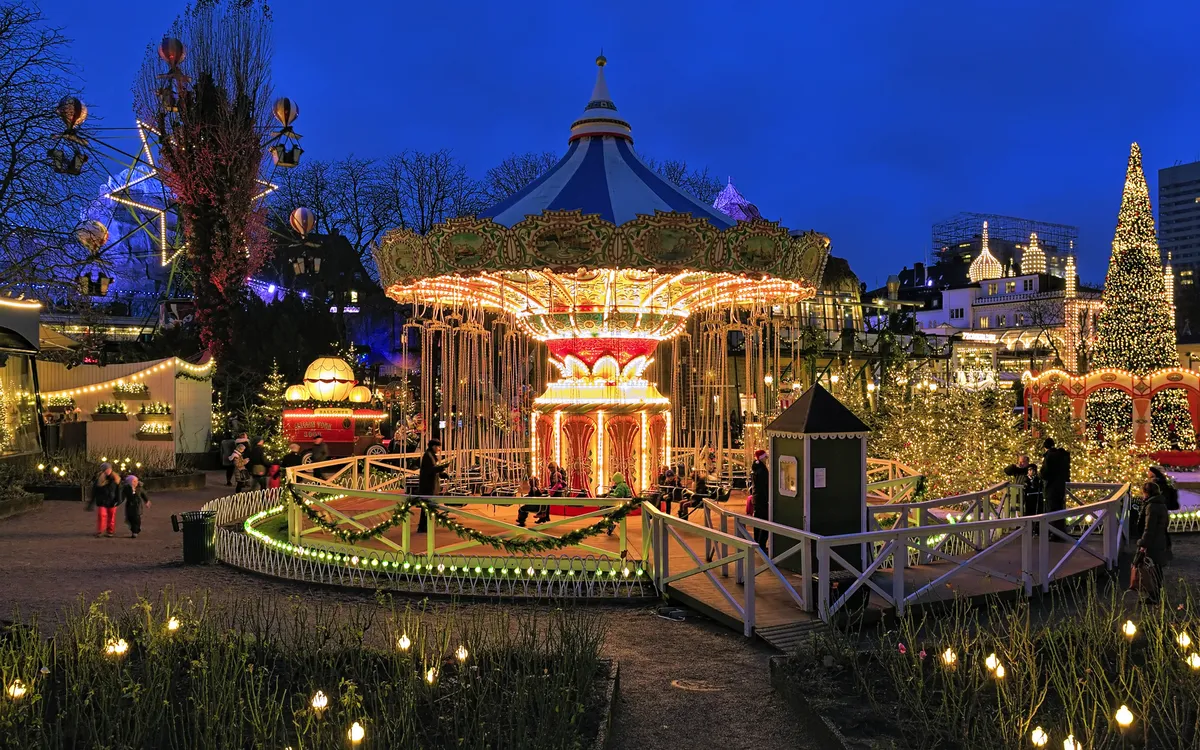 Karussell im Tivoli in Kopenhagen, beleuchtet zur Weihnachtszeit am Abend.