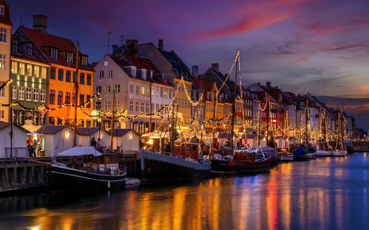 Winterabend im beleuchteten Nyhavn, Kopenhagen mit weihnachtlicher Dekoration.