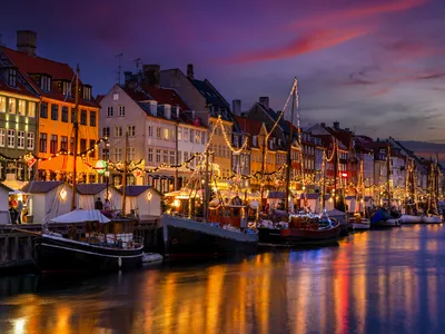 Winterabend im beleuchteten Nyhavn, Kopenhagen mit weihnachtlicher Dekoration.