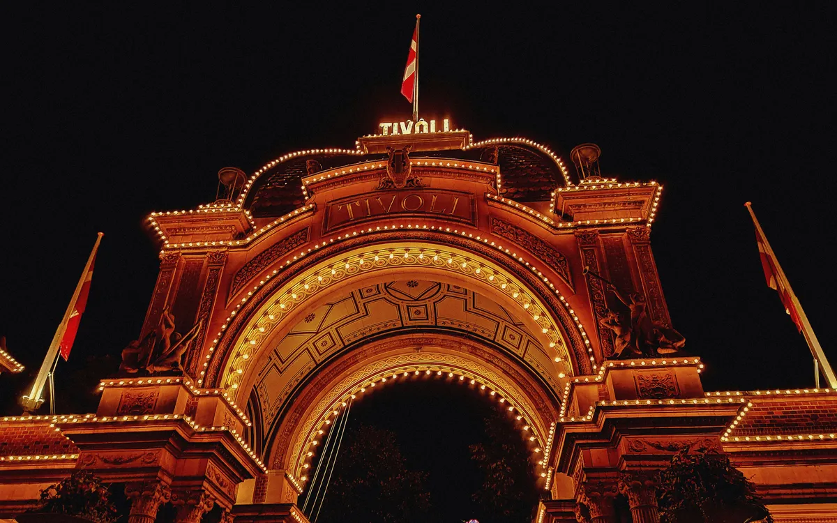 Beleuchteter Eingang des Tivoli in Kopenhagen bei Nacht.