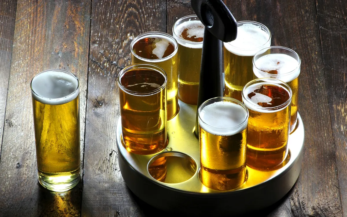 Verschiedene Gläser mit Bier auf einem Holzuntergrund.
