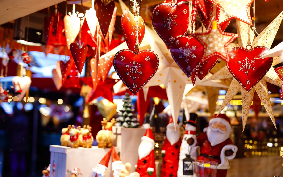 Weihnachtsmarkt mit Dekorationen, Herzen und Sternen aus Licht.