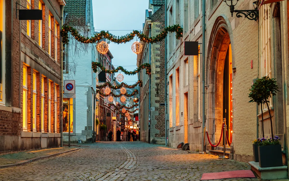 Eine weihnachtlich dekorierte, gepflasterte Altstadtstraße.