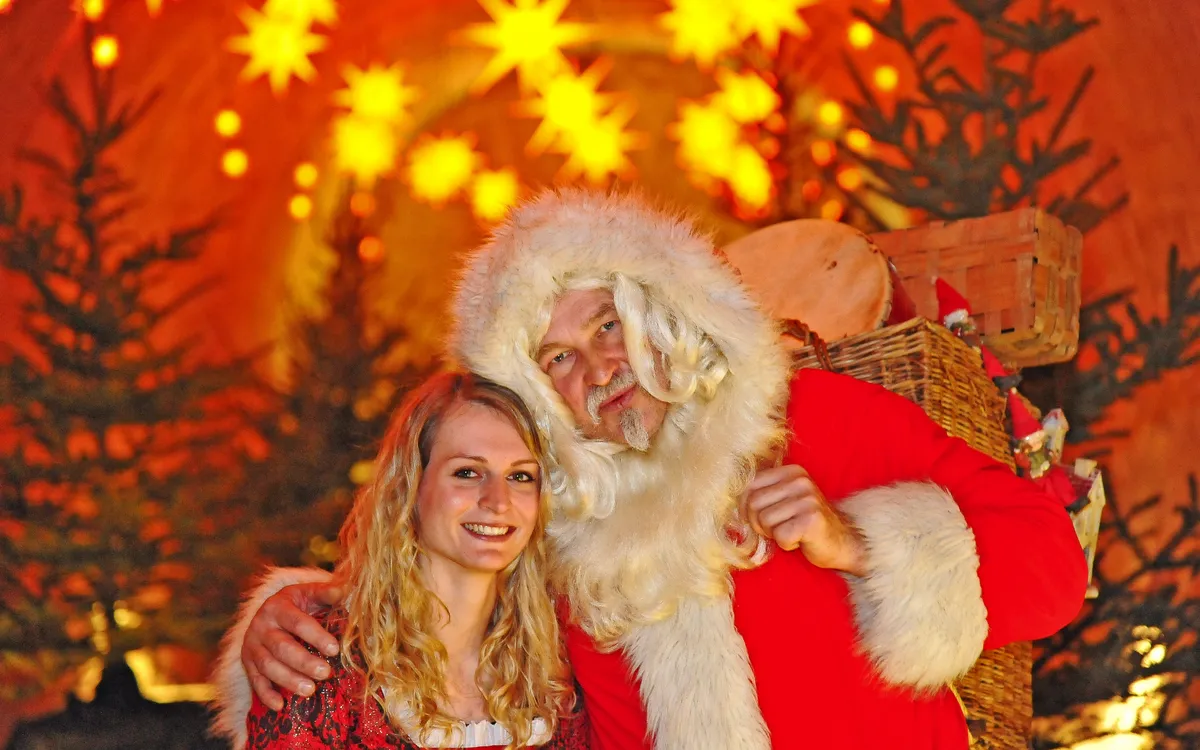 Weihnachtsmann mit Frau vor beleuchtetem Hintergrund in der Festung Königstein