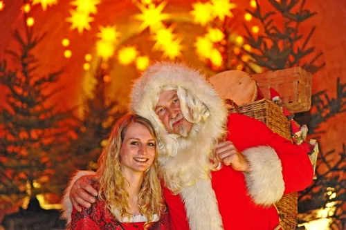 Weihnachtsmann mit Frau vor beleuchtetem Hintergrund in der Festung Königstein