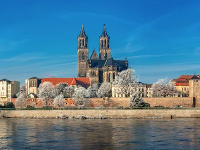 Winterliche Stadtansicht mit einer Kathedrale und Fluss im Vordergrund.