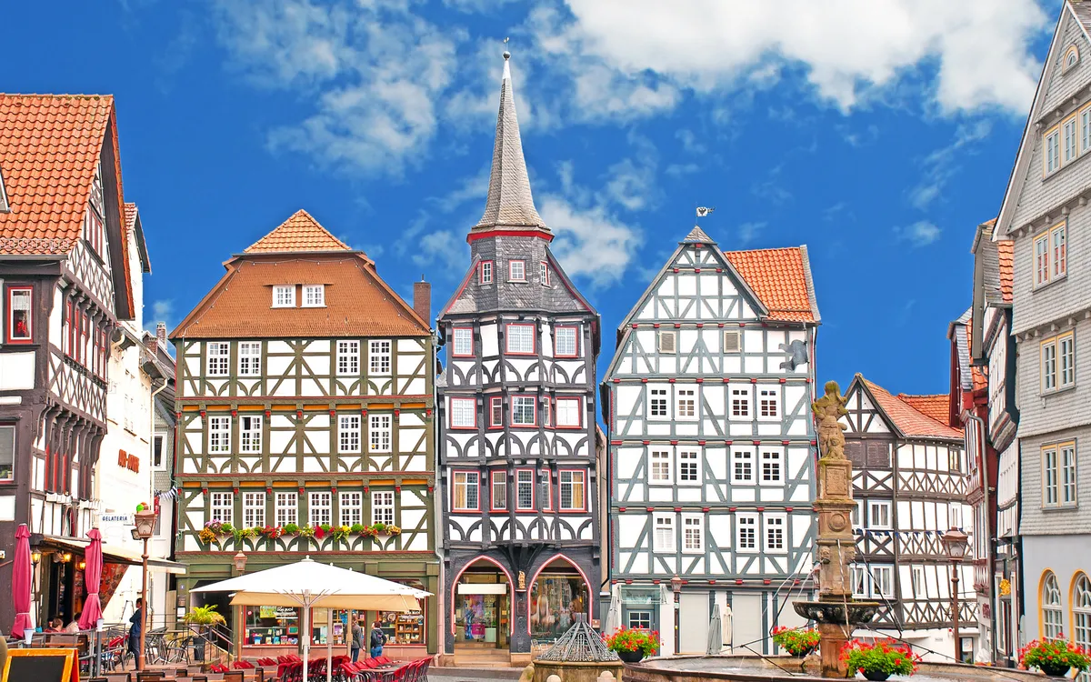 Fachwerkhäuser an einem historischen Marktplatz unter blauem Himmel.