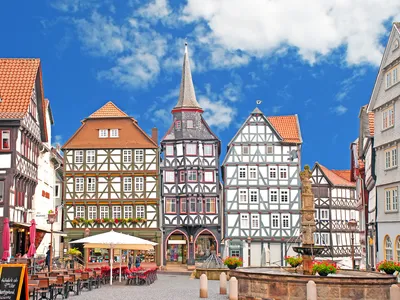 Fachwerkhäuser an einem historischen Marktplatz unter blauem Himmel.