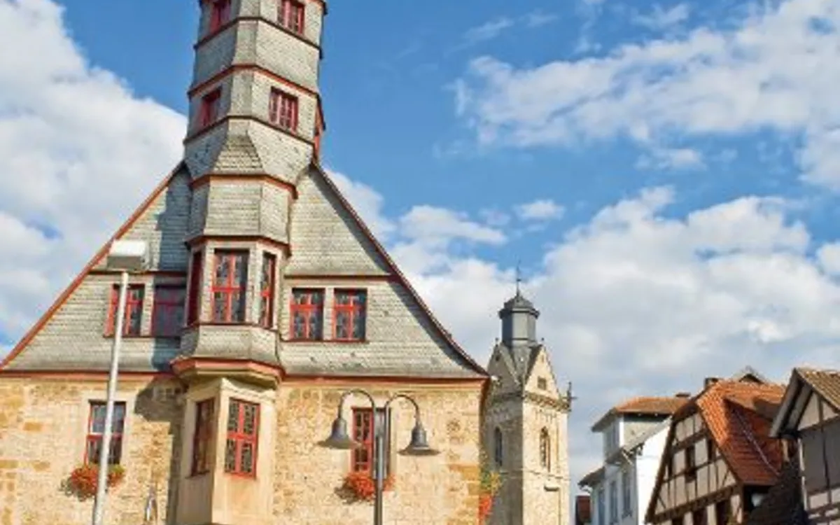 Fachwerkhäuser und historisches Gebäude in einer deutschen Altstadt bei Sonnenschein.