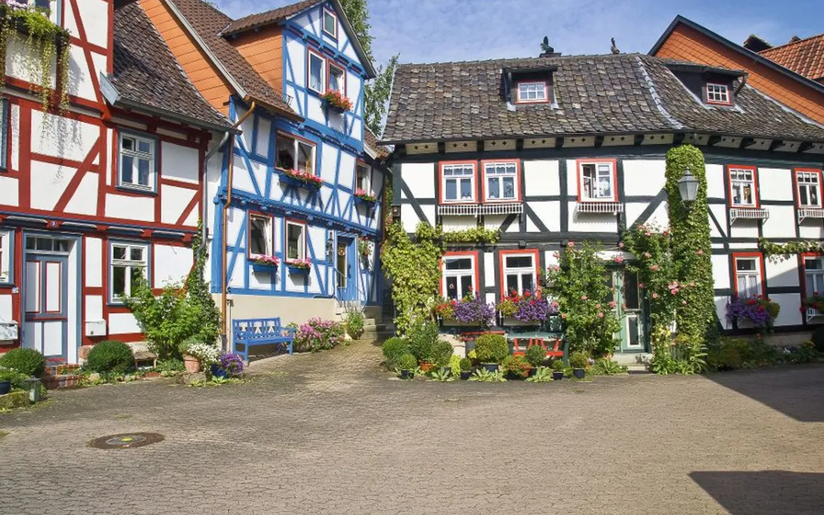 Fachwerkhäuser in einem malerischen Hof bei sonnigem Wetter.