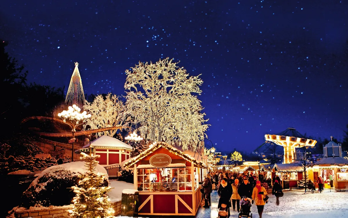 Winterlicher Weihnachtsmarkt im verschneiten Freizeitpark Liseberg, Göteborg.