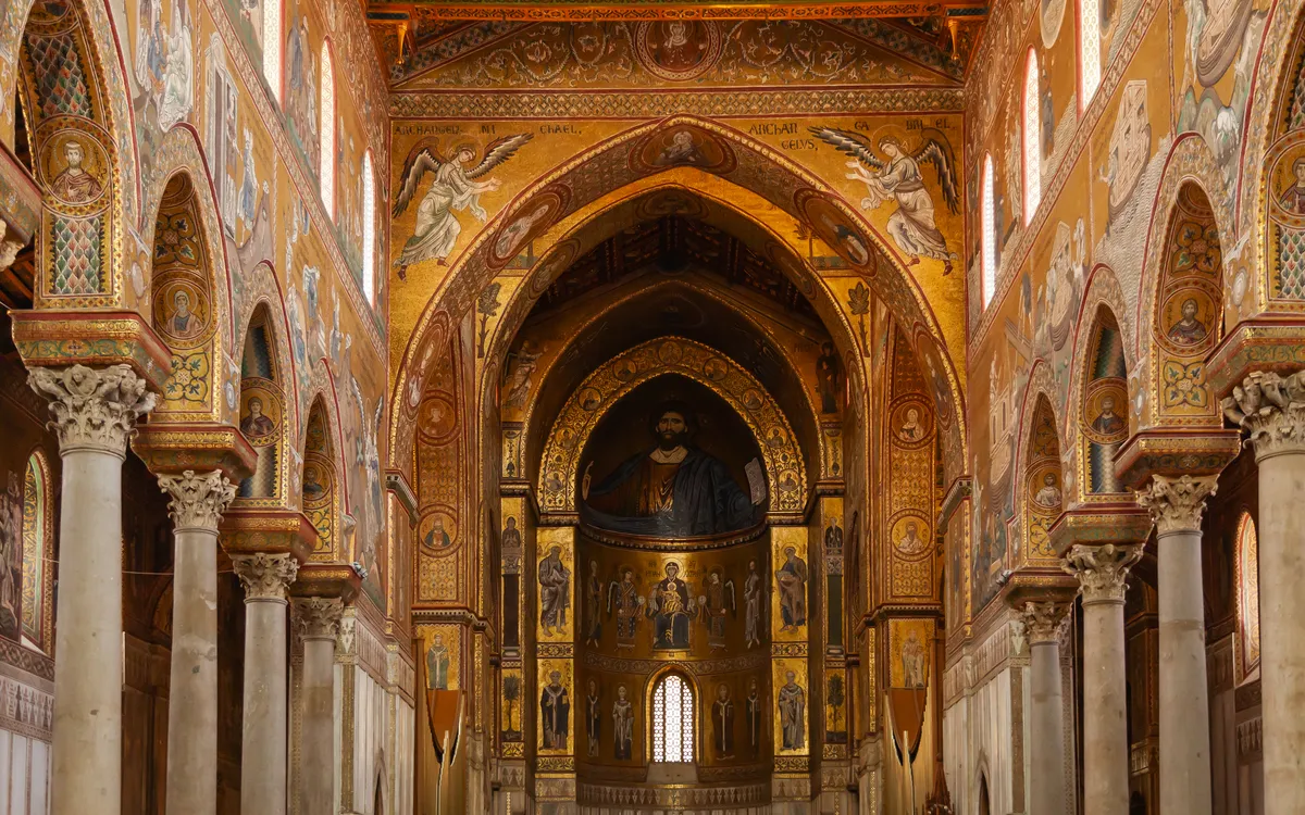 Innenansicht einer reich verzierten, historischen Kirche mit Gemälden und Bögen.