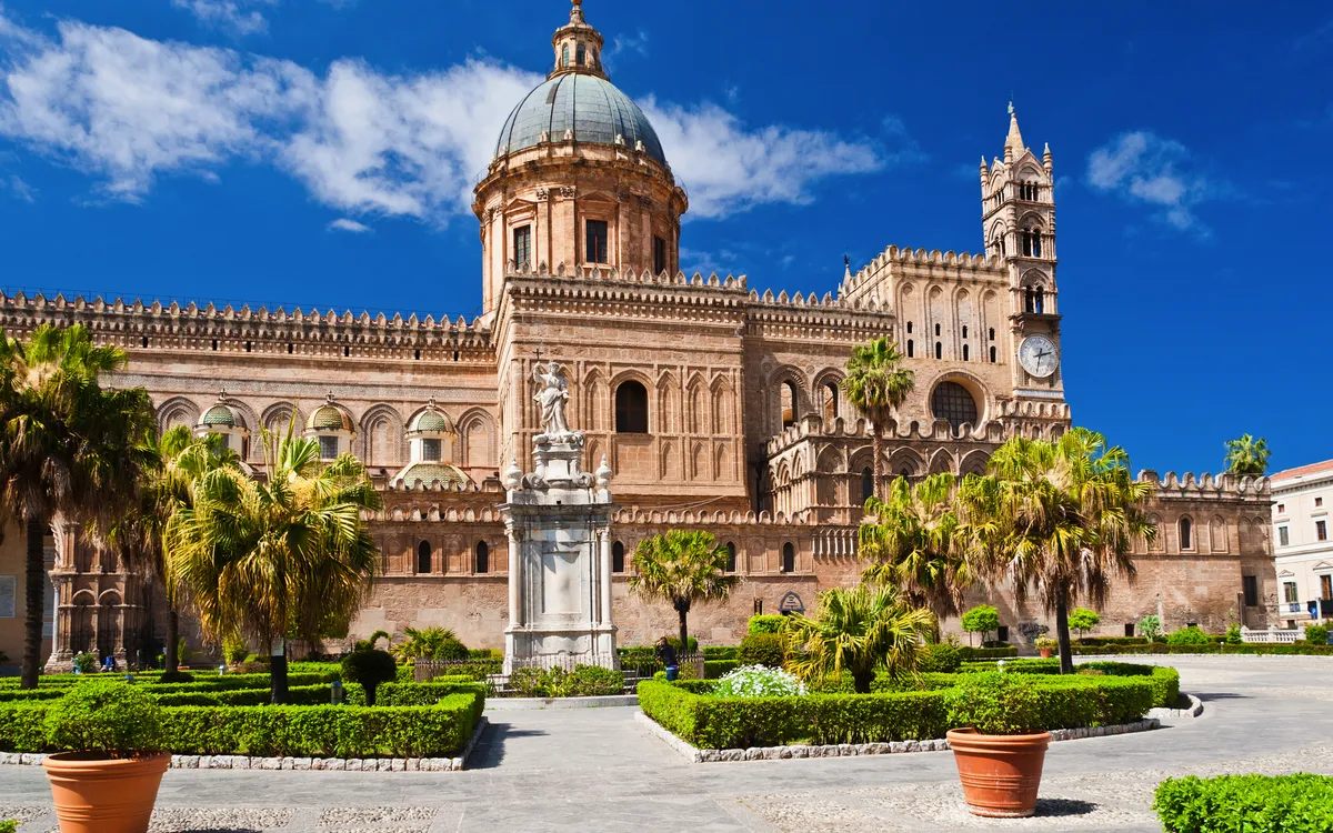 Kathedrale von Palermo mit Gärten und blauen Himmel im Hintergrund.