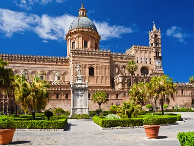 Kathedrale von Palermo mit Gärten und blauen Himmel im Hintergrund.