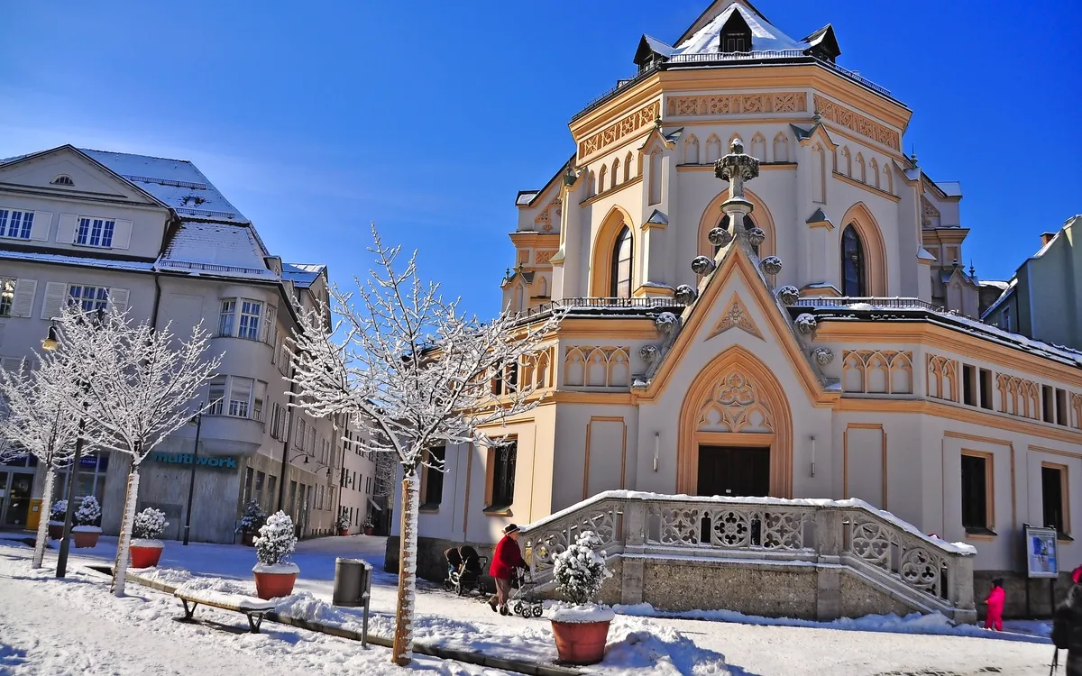 Wintertag in Rosenheim mit einer verschneiten Kirche und blauem Himmel