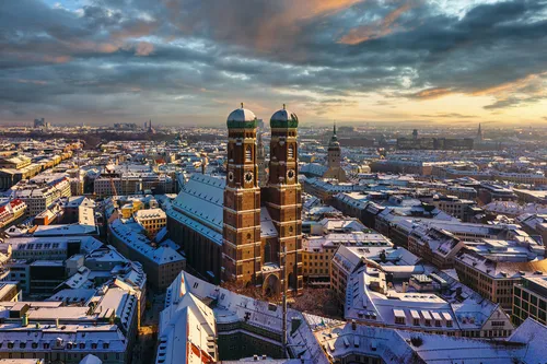 Verschneite Stadtansicht von München mit der Frauenkirche im Zentrum.
