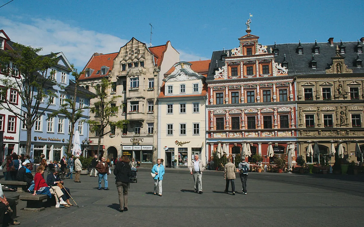 Historische Gebäude am Fischmarkt in Erfurt bei sonnigem Wetter, Menschen flanieren.