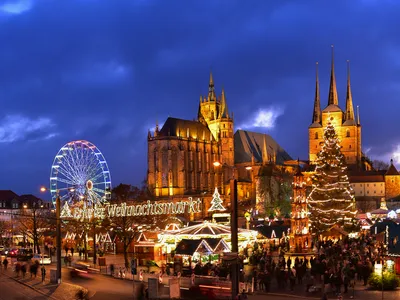 Weihnachtsmarkt in Erfurt bei Abenddämmerung mit Dom und Riesenrad im Hintergrund